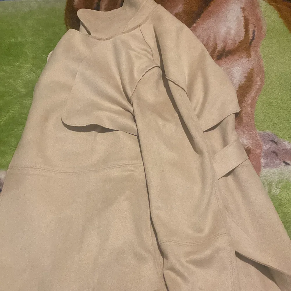 Säljer en stilren beige kappa från H&M i storlek XS. Den har en elegant design med långa ärmar och en mjuk känsla. Perfekt för höst och vår när du vill ha något snyggt och bekvämt.. Jackor.