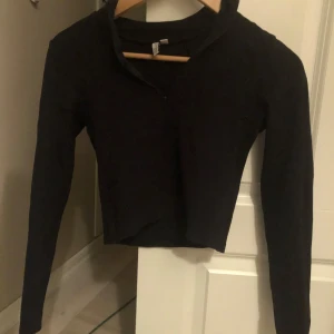 Svart långärmad tröja - Snygg svart långärmad tröja med v-ringning. Perfekt för en stilren look och passar bra till både jeans och kjol.