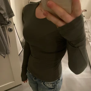 Grön långärmad topp från Weekday - Säljer en stilren grön långärmad topp från Weekday. Toppen har en tight passform och är tillverkad i ett mjukt material som känns skönt mot huden. Perfekt för lager-på-lager eller som den är💗