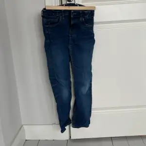 Säljer ett par snygga blå jeans från Lindex i storlek 146. De har en smal passform och klassisk femficksdesign. Perfekta för vardagsbruk!