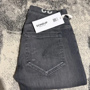 Dondup Jeans - Ett par Dondup George jeans i en väldigt fin grå färg (Storlek 32). Jeansen är helt nya utan defekter med alla lappar kvar på. Nypriset ligger på ca 3799kr, men jag säljer de för endast 999kr. Kan även gå med på vissa byten. Hör gärna av er vid eventuella frågor eller bytesförslag! 🤝🤩