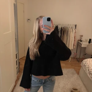 Svart stickad tröja - Svart stickad tröja med en vis urringning från H&M i storlek S