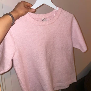 Rosa stickad tröja från Nelly - Säljer en söt rosa stickad tröja från Nelly!🥰🥰Tröjan har korta ärmar och är lite kortare. Använd några gånger men inga tecken på användning.