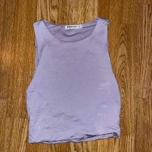 Lila ärmlös topp från Stradivarius - Säljer en stilren lila ärmlös topp från Stradivarius. Perfekt för varma dagar eller som ett lager under en jacka. Tillverkad i ett mjukt och bekvämt material.