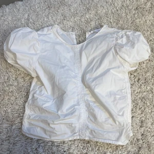 Vit blus från Zara - Säljer en söt vit blus från Zara med puffiga kortärmar och rund halsringning. Perfekt för en stilren och enkel look. Blusen är i storlek 152 och passar för barn i åldern 11-12 år.💞✨