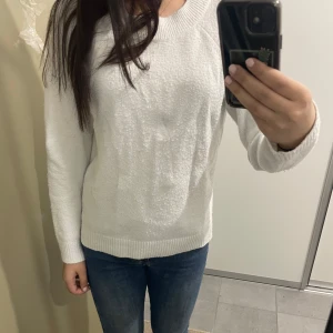Vit stickad tröja - Säljer en stilren vit stickad tröja med rund hals och långa ärmar. Perfekt för kyligare dagar och lätt att matcha med olika outfits. 