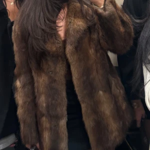 Brun pälsjacka - Säljer en lyxig brun pälsjacka med långärmad design. Jackan har en elegant och tidlös stil, perfekt för att hålla sig varm. Äkta päls 