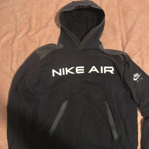 Svart hoodie från Nike Air - Säljer en svart hoodie från Nike Air med stor logga på framsidan. Tröjan har en klassisk huva och långa ärmar. Perfekt för en avslappnad stil.