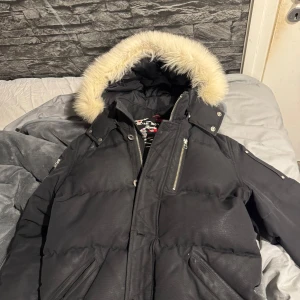 Svart dunjacka med pälsdetalj - Moose knuckles vinterjacka storlek m