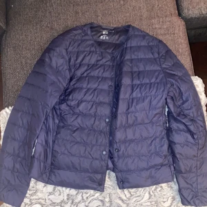 Blå ultralätt dunjacka från Uniqlo - Hej! Säljer en tunn jacka från uniqlo i färgen blå.Jackan är i nytt skick.Vid intresse skriv!