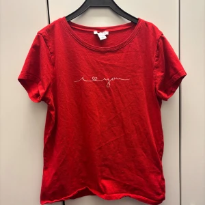 Röd t-shirt från Amisu - Snygg röd t-shirt från Amisu med texten 'I love you' i vitt på framsidan. Den har en rund halsringning och korta ärmar, perfekt för en avslappnad stil. Tycker även den passar mindre barn.