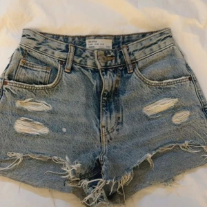 Blå jeansshorts från Bershka - Snygga blå jeansshorts från Bershka med slitna detaljer. Mycket bra skick