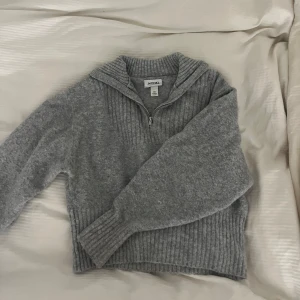 Grå stickad half zipup  - Jättefin grå halv zipup stickad tröja från monki! Strlk xxs men skulle säga att den passar från s-xxs. Bra skick och mjukt material, använd fåtal gånger!