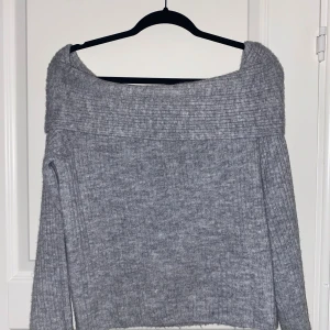 Grå offshoulder tröja - Säljer en mysig grå offshoulder tröja med ribbad kant. Perfekt för kyliga dagar med sin stickade design och långa ärmar. En stilren och bekväm tröja för alla tillfällen. Oanvänd, endast provad. Köpt på H&M för 200kr. Hör av dig vid frågor💞