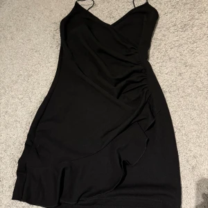 Perfekt svart mini klänning - Superfin perfekt svart miniklänning som aldrig använts, har söta volanger och detaljer