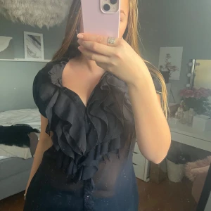 blus med volanger - Otroligt fin blus men fina eleganta detaljer. Perfekt till jeans eller kostymbyxor. Köpt secondhand men är helt oanvänd av mig. Är i xl men sitter mer som en m.