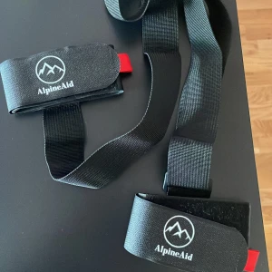 Svart skidbärare från AlpineAid - Säljer svarta skidbärare från AlpineAid. Bärremmen har en justerbar rem med kardborreband och en röd detalj. Perfekt för att underlätta bärningen av skidorna. Kommer från ett tidigare UF företag och säljer nu ut oanvända skidbärare till ett billigt pris, 50kr/st