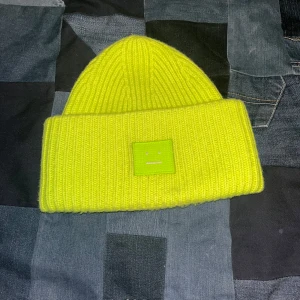 Grön mössa från Acne Studios - Säljer en snygg mössa från Acne Studios med ribbad design, Perfekt för att lysa upp din vinterstil!