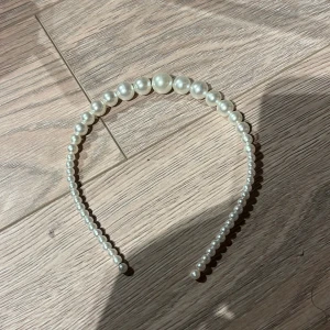 Diadem med pärlor - Elegant diadem dekorerat med vita pärlor i olika storlekar. Perfekt för att ge en stilfull touch till din look. Passar bra till både vardag och speciella tillfällen.