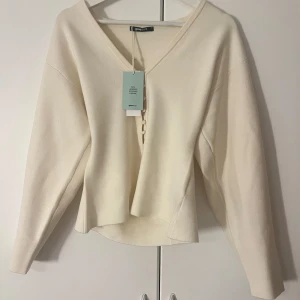 Vit v-ringad tröja från Ginatricot - Säljer en stilren vit tröja från gonatricot med v-ringning. Tröjan har långa ärmar och en lös passform, perfekt för en avslappnad look. Den är tillverkad i ett mjukt material som känns skönt mot huden. Väldigt populär tröja! Helt ny med prislapp kvar