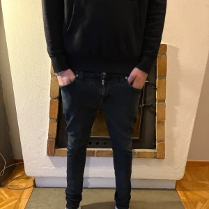 Mörkblå jeans från Nudie Jeans - Snygga mörkblå jeans från Nudie Jeans med en klassisk femficksdesign. De har en dragkedja och knapp framtill. Perfekta för en stilren look. 