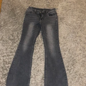 Grå bootcut jeans - Snygga grå bootcut jeans med dragkedja och knapp framtill. De har en klassisk femficksdesign och en lätt tvättad look som ger en cool vintagekänsla. Perfekta för en avslappnad stil.