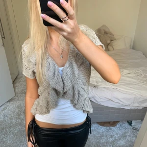 Kofta / bolero med volanger - Säljer denna kofta / bolero med volanger. På första och andra bilden har jag knäppt ihop den med en säkerhetsnål, men går såklart även att ha öppen. Har du någon fråga är det bara att höra av dig🫶🏻