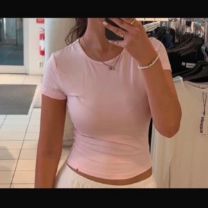 Rosa kortärmad topp från Shein - Säljer en söt rosa kortärmad topp från Shein. Den är gjord i ett mjukt och bekvämt material, perfekt för en avslappnad stil. Toppen har en enkel design som gör den lätt att matcha med olika outfits.