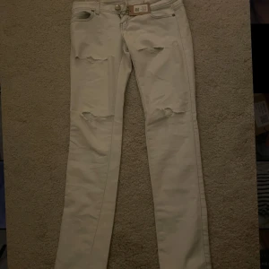Off-white jeans från Tally Weijl - Snygga off-white jeans från Tally Weijl i en slim passform. De har slitna detaljer på framsidan som ger en trendig look. Aldrig använt och lågmidjade 