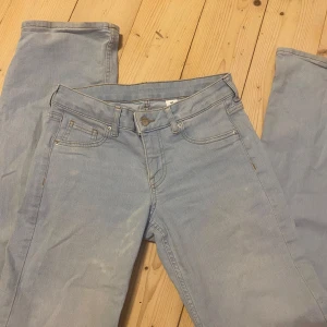 Låg midjade Ljusblå jeans - Säljer ett par ljusblå jeans med klassisk femficksdesign och knappgylf. Bootcut och låg midjade. 