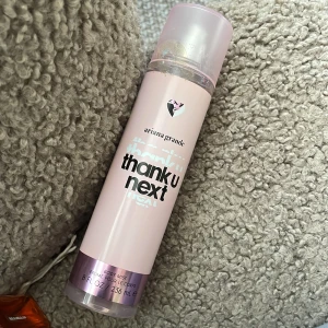 Ariana Grande Thank U Next Body Mist - Säljer en body mist från Ariana Grande med doften Thank U Next. Flaskan är ljusrosa med ett trasigt hjärta som dekoration. Innehåller 236 ml och är perfekt för en lättare doftupplevelse. Perfekt för dig som älskar fräscha och ungdomliga dofter. Köpte på normal och där är det klisterlappar då så därför lim på korken. Den är helt full