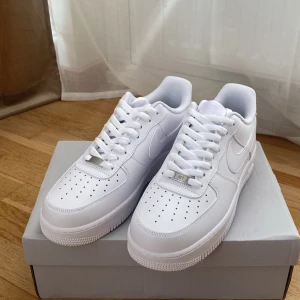 Vita Nike Air Force 1 sneakers - Jag säljer ett par vita Nike Air Force 1, en tidlös och odödlig sneaker som aldrig går ur mode. Dessa skor har endast testats, så de är i absolut nyskick och ser ut som nya. Air Force 1 är kända för sin klassiska design och komfort, och de passar perfekt till nästan alla outfits – från casual till lite mer uppklätt.  Skorna har följande specifikationer: * Color: white, * Size: 42.5 eu, * Cond: 10/10   Tveka inte att höra av dig om du har några frågor eller om du vill se fler bilder!