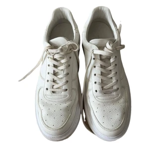 Vita sneakers  från Louis Vuitton - Snygga vita sneakers från Louis Vuitton med klassisk design och perforerade detaljer på ovansidan. Skorna har snörning och märkets ikoniska logotyp på sidan och hälen. Perfekta för en stilren look. Vita med guld. Köpt på Vestiaire. Äkta sneakers. Det finns en skada under innersulan men inget man bemärker. Köpt utan kartong eller annat säljas enbart för dom inte passar mina fötter. 