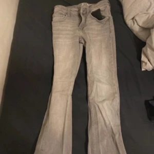 Grå lågmidjade bootcut jeans från 157 - Snygga grå bootcut jeans från 157 i storlek XS. De har en klassisk femficksdesign med dragkedja och knapp framtill. Perfekta för en avslappnad stil.