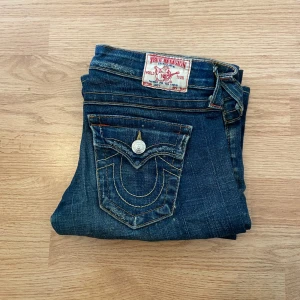 True Religion Jeans Bootcut Flare  - !skicka bud för snabb affär! True religion jeans, storlek 26 i jätte bra skick. Lite distressing på knäet. Mått:                                                                                Midja 38 cm  Ytterben 100,5 cm Innerben 81 cm Ben öppning 24 cm