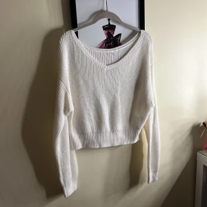 Vit stickad tröja med v-ringning - Säljer en stilren vit stickad tröja med v-ringning. Tröjan har långa ärmar och en ribbad struktur som ger en klassisk look. Perfekt för kyligare dagar. Den är väldigt kort i magen, tyvärr vet jag inte vart den är från då jag köpte den av en annan tjej på Plick och lappen är borta💓