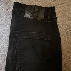  Siksilk jeans  - Snygga svarta jeans med slitningar på framsidan. De är helt nya.. Storlek M funkar L… Byxorna har en klassisk femficksdesign och en läderpatch med logotyp baktill. Vid funderingar så skicka personligt meddelande.
