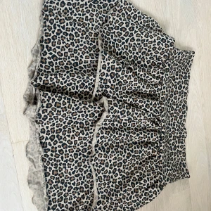 Leopardmönstrad kjol från H&M - Snygg leopardmönstrad kjol från H&M med volanger. Perfekt för att ge din outfit en trendig touch. Kjolen har en bekväm passform och är lätt att matcha med olika toppar.