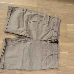 Beige shorts med fickor - Snygga beige shorts från HM storlek 34 slimfit med klassisk design och praktiska fickor både fram och bak. Perfekta för en avslappnad stil. De har en normal passform och är tillverkade i ett bekvämt material.