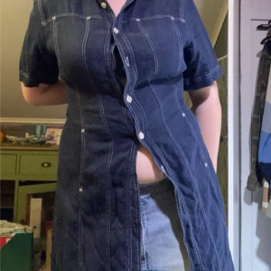 Mörk jeansrock med knappar - Snygg mörk jeansrock med korta ärmar och knappar framtill. 