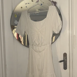 Vit klänning från Lindex - Charmig vit klänning från Lindex med korta puffärmar och en söt knytdetalj baktill . Klänningen har en luftig passform och är perfekt för varma dagar. Tillverkad i ett lätt och bekvämt material. Priset kan diskuteras❤️❤️