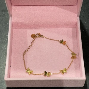 Guldarmband med fjärilar - Elegant guldarmband med små fjärilar som dekoration. Armbandet har en fin kedja och justerbar längd med ett litet lås. Perfekt för att lägga till en touch av elegans till din stil. Samt vattentåligt 