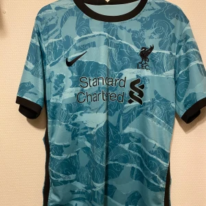 Turkos fotbollströja från Nike - Snygg turkos fotbollströja från Nike med svart logga och klubbmärke. Är du ingen medgångare så vet du hur dåliga liverpool var den här säsongen, i mot och i medgång.