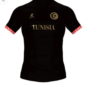 Svart fotbollströja med Tunisien-tryck (LAIB) - Snygg svart fotbollströja med guldtryck av texten 'TUNISIA' och en stjärna och måne. Tröjan har korta ärmar med ett rött och vitt mönster vid ärmsluten. (Oanvänd!!!)
