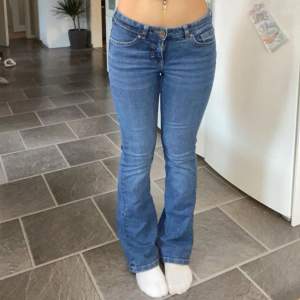 Säljer ett par snygga blå bootcut jeans. De är lågmidjade och har en klassisk femficksdesign med knappar och dragkedja framtill. Inga difekter! Midjemått: 35cm Passar i längden på mig som är 165! 🩷