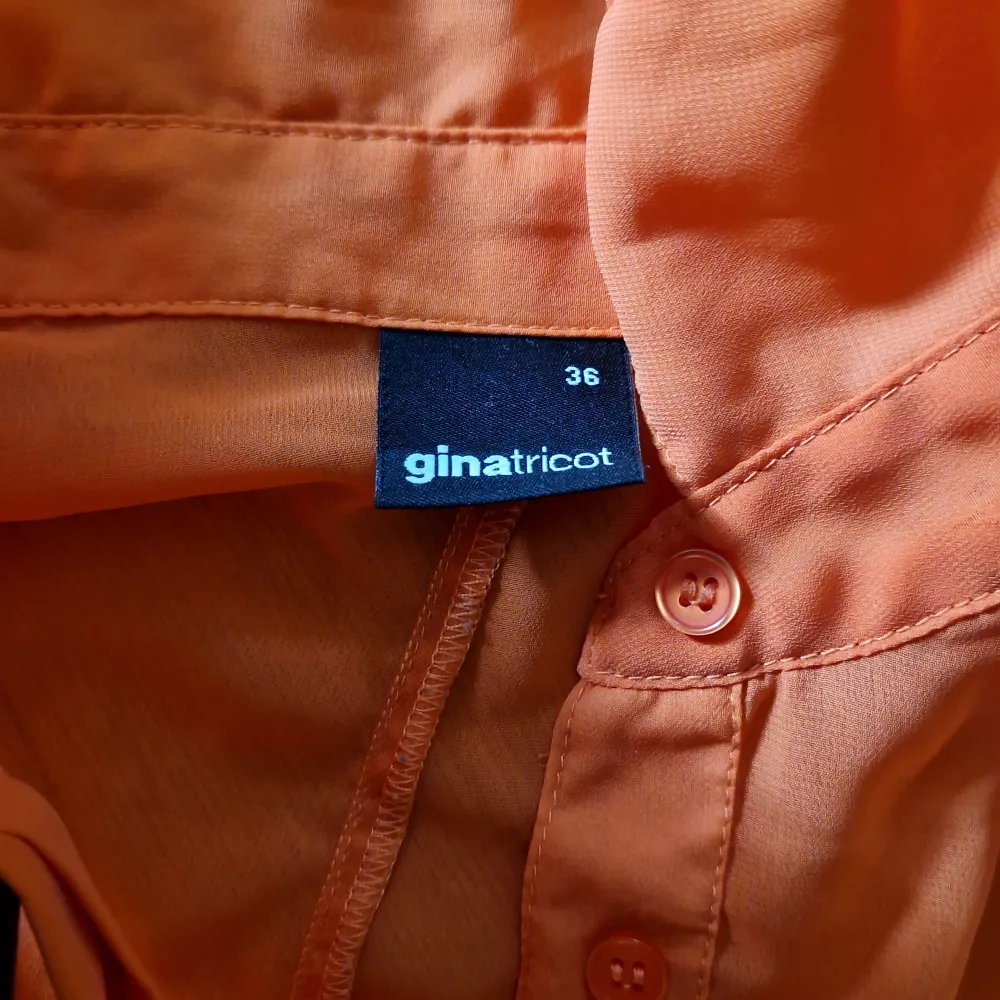 Säljer en snygg orange skjorta från Gina Tricot i storlek 36. Skjortan har en avslappnad passform med en bröstficka och knappar framtill. Perfekt för en färgglad vardagslook eller att piffa upp en outfit. Materialet känns lätt och bekvämt.. Skjortor.