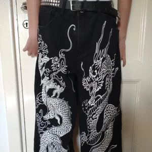 Emo baggy jeans - Emo baggy jeans med drakar på. Knappt använda. Är storlek large men funkar definitivt för alla mindre storlekar eftersom de är baggy. (Bältet är ej till salu)