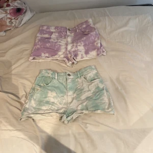 Tie-dye shorts från H&M - Säljer två par supercoola tie-dye shorts från H&M. Ett par är lila och vitt, och det andra paret är grönt och vitt. Båda har en knapp och dragkedja framtill, samt fickor både fram och bak. Perfekta för sommaren och riktigt sköna att ha på sig. De lila är i storlek 164 och de gröna i 170. Båda kostar 20 men kan säljas enskild för 10 kr/st