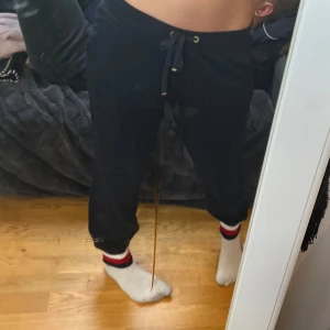 Tommy hilfiger marinblåa mjukisar - Säljer ett par mörkblåa mjukisbyxor från Tommy hilfiger som är superbekväma och perfekta för chill dagar hemma. De har en snörning i midjan för justerbar passform och muddar vid bensluten. Passar perfekt för en avslappnad stil!