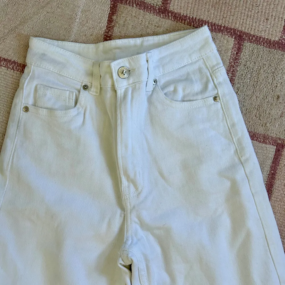 Nya wide leg jeans med hög midja från H&M i färgen vit, storlek 32/xxs. Aldrig använda då de är för små i storleken och långa i benen för mig. Original pris - 299kr.  Material: 98% bomull 2% elastan Insida ben längd: 80 cm. Jeans & Byxor.